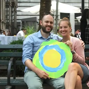 Um casal em um banco com o logotipo da Idealist entre eles.