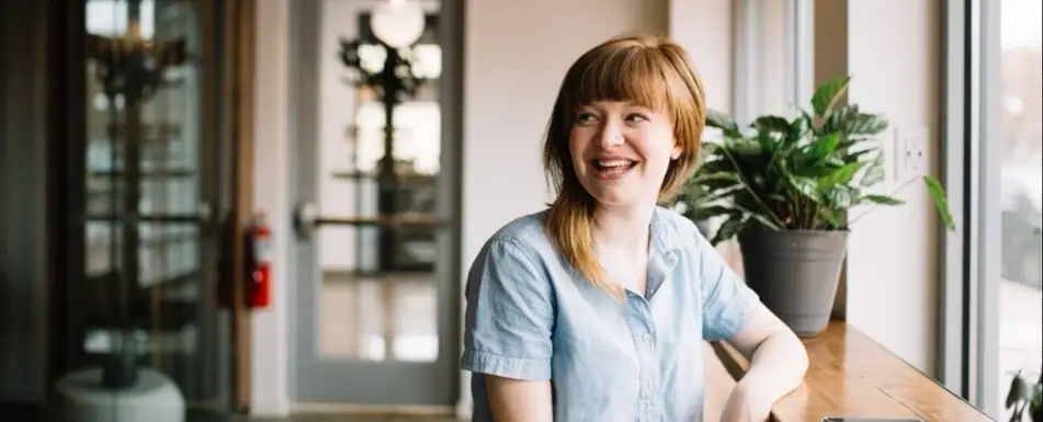 A woman sitting and smiling.