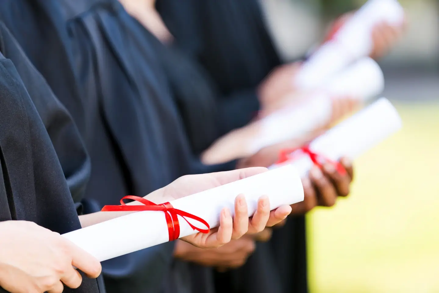 Photograph of graduates with diplomas.