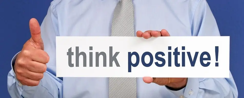 Someone holding up a sign that says, "think positive!"